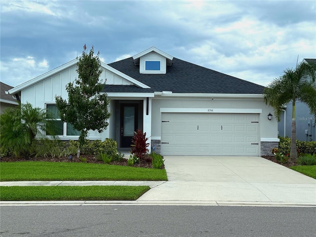 8706 Arrow Creek Dr, Parrish, FL 34219 - view of front of house with an attached garage, board and batten siding, a shingled roof, driveway, and stone siding