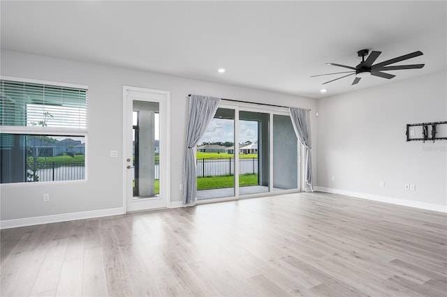 8706 Arrow Creek Dr, Parrish, FL 34219 - unfurnished living room with wood finished floors, ceiling fan, and recessed lighting