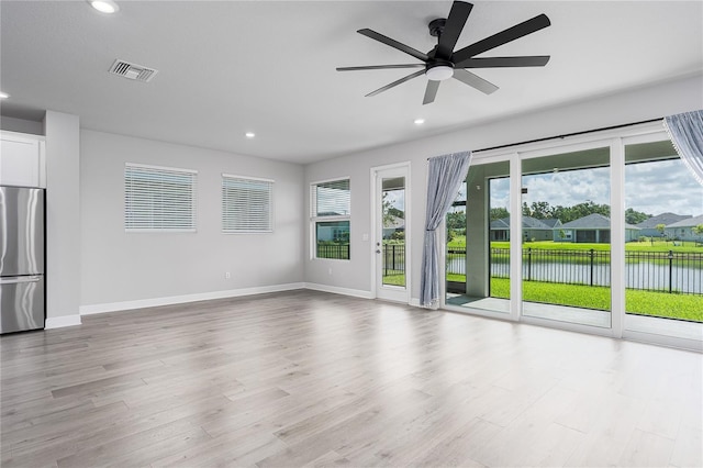 8706 Arrow Creek Dr, Parrish, FL 34219 - unfurnished living room featuring a water view, recessed lighting, wood finished floors, and ceiling fan