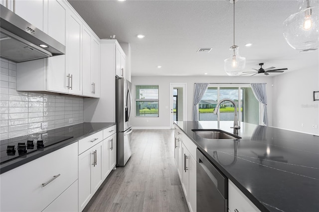 8706 Arrow Creek Dr, Parrish, FL 34219 - kitchen with exhaust hood, appliances with stainless steel finishes, dark countertops, recessed lighting, and light wood finished floors