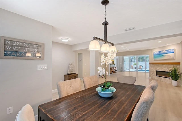 444 S Polk Dr, Sarasota, FL 34236 - dining space with a glass covered fireplace and wood finished floors