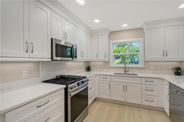 444 S Polk Dr, Sarasota, FL 34236 - kitchen featuring appliances with stainless steel finishes, white cabinetry, light wood-style floors, recessed lighting, and light stone counters