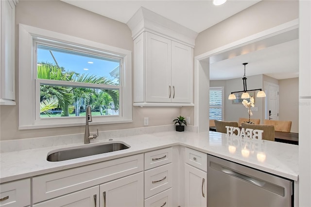 444 S Polk Dr, Sarasota, FL 34236 - kitchen with stainless steel dishwasher, white cabinets, hanging light fixtures, light stone countertops, and a chandelier