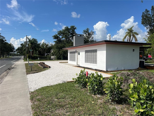 4122 N Lockwood Ridge Rd, Sarasota, FL 34234 - view of side of home featuring stucco siding and a chimney