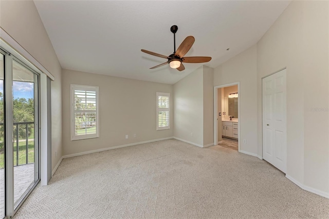 803 Montrose Dr Unit 201, Venice, FL 34293 - unfurnished bedroom featuring vaulted ceiling, access to outside, multiple windows, light colored carpet, and ensuite bathroom