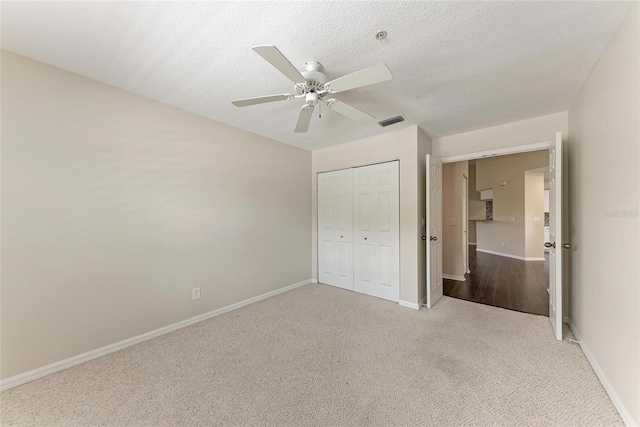803 Montrose Dr Unit 201, Venice, FL 34293 - unfurnished bedroom featuring carpet, a closet, a ceiling fan, and a textured ceiling