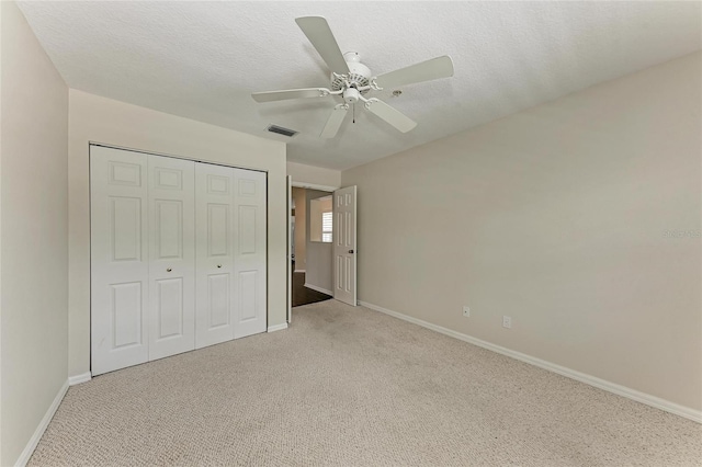803 Montrose Dr Unit 201, Venice, FL 34293 - unfurnished bedroom with light colored carpet, a closet, a ceiling fan, and a textured ceiling