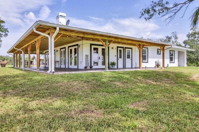 39700 State Road 70 E, Myakka City, FL 34251 - back of property with french doors, a yard, a chimney, and stucco siding