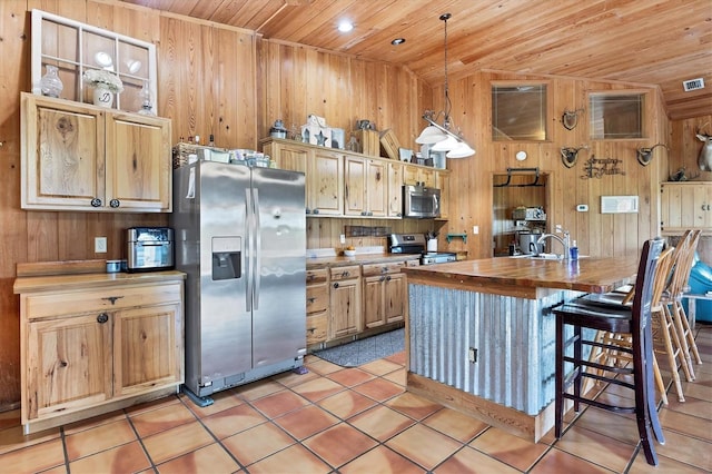 39700 State Road 70 E, Myakka City, FL 34251 - kitchen with stainless steel appliances, wooden ceiling, wood walls, butcher block counters, and light tile patterned flooring