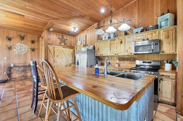 39700 State Road 70 E, Myakka City, FL 34251 - kitchen with stainless steel appliances, butcher block counters, wooden walls, wooden ceiling, and light tile patterned floors