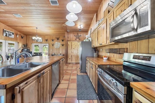 39700 State Road 70 E, Myakka City, FL 34251 - kitchen featuring butcher block counters, appliances with stainless steel finishes, wood ceiling, a chandelier, and wood walls