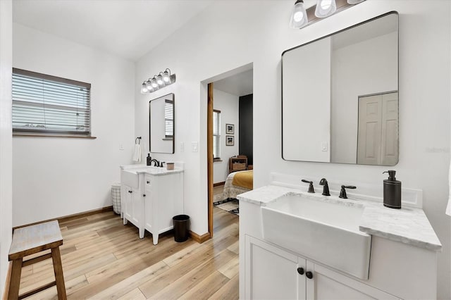39700 State Road 70 E, Myakka City, FL 34251 - full bathroom with two vanities, wood finished floors, plenty of natural light, and ensuite bathroom
