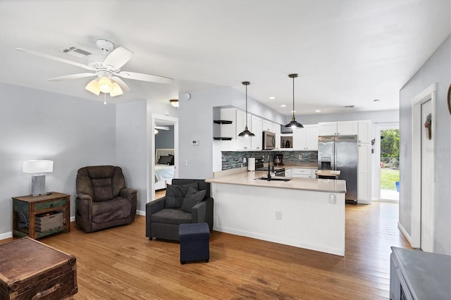 1778 N Salford Blvd, North Port, FL 34286 - kitchen featuring appliances with stainless steel finishes, open floor plan, a peninsula, light wood-style floors, and ceiling fan