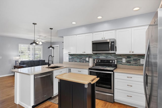 1778 N Salford Blvd, North Port, FL 34286 - kitchen featuring stainless steel appliances, a peninsula, backsplash, white cabinets, and butcher block counters