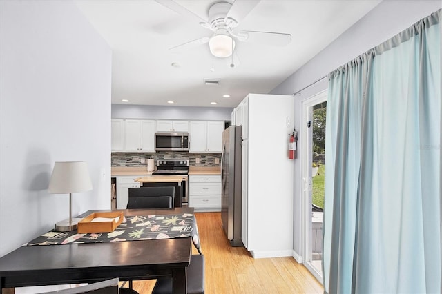 1778 N Salford Blvd, North Port, FL 34286 - kitchen with stainless steel appliances, white cabinets, decorative backsplash, light countertops, and light wood-type flooring