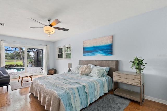538 Magellan Dr, Sarasota, FL 34243 - bedroom with multiple windows, wood finished floors, a ceiling fan, and access to outside