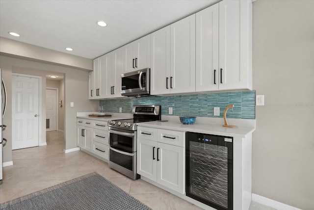 538 Magellan Dr, Sarasota, FL 34243 - kitchen with wine cooler, stainless steel appliances, backsplash, light countertops, and white cabinetry