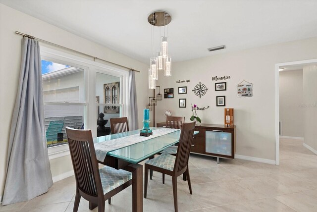 538 Magellan Dr, Sarasota, FL 34243 - dining room with light tile patterned floors and a chandelier
