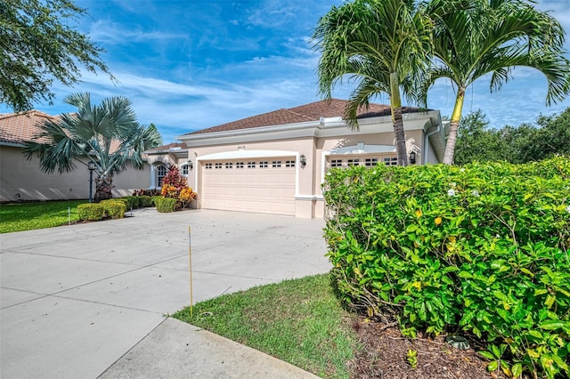6610 Rosy Barb Ct, Lakewood Ranch, FL 34202 - mediterranean / spanish-style home with stucco siding, an attached garage, and driveway
