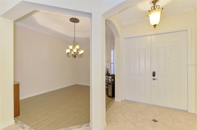 6610 Rosy Barb Ct, Lakewood Ranch, FL 34202 - entrance foyer featuring arched walkways, crown molding, a chandelier, a tray ceiling, and light wood-type flooring