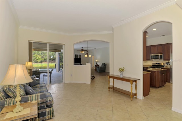 6610 Rosy Barb Ct, Lakewood Ranch, FL 34202 - living area with arched walkways, light tile patterned flooring, and ornamental molding