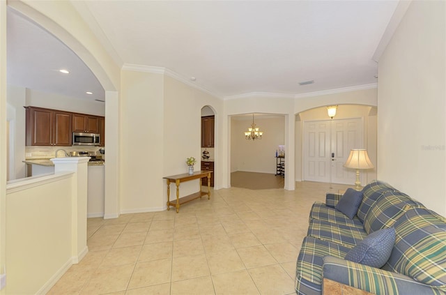 6610 Rosy Barb Ct, Lakewood Ranch, FL 34202 - living area with arched walkways, a chandelier, light tile patterned floors, and crown molding