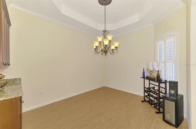 6610 Rosy Barb Ct, Lakewood Ranch, FL 34202 - unfurnished room featuring a tray ceiling, a chandelier, light wood-style flooring, and ornamental molding