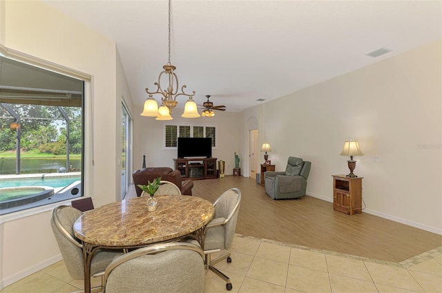 6610 Rosy Barb Ct, Lakewood Ranch, FL 34202 - dining area with light tile patterned flooring, a chandelier, and a ceiling fan