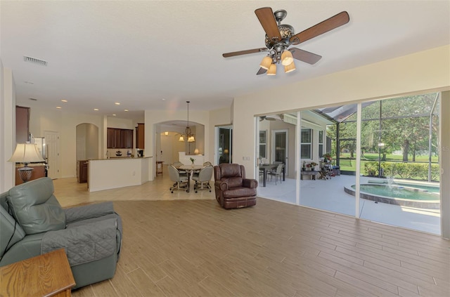 6610 Rosy Barb Ct, Lakewood Ranch, FL 34202 - living area with arched walkways, a ceiling fan, a sunroom, light wood-type flooring, and recessed lighting