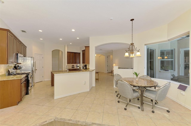 6610 Rosy Barb Ct, Lakewood Ranch, FL 34202 - dining space with arched walkways, light tile patterned flooring, recessed lighting, and a chandelier