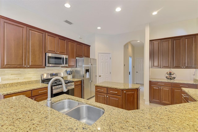 6610 Rosy Barb Ct, Lakewood Ranch, FL 34202 - kitchen with appliances with stainless steel finishes, arched walkways, light stone counters, decorative backsplash, and recessed lighting