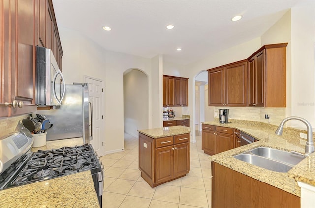 6610 Rosy Barb Ct, Lakewood Ranch, FL 34202 - kitchen featuring arched walkways, appliances with stainless steel finishes, backsplash, light stone countertops, and recessed lighting