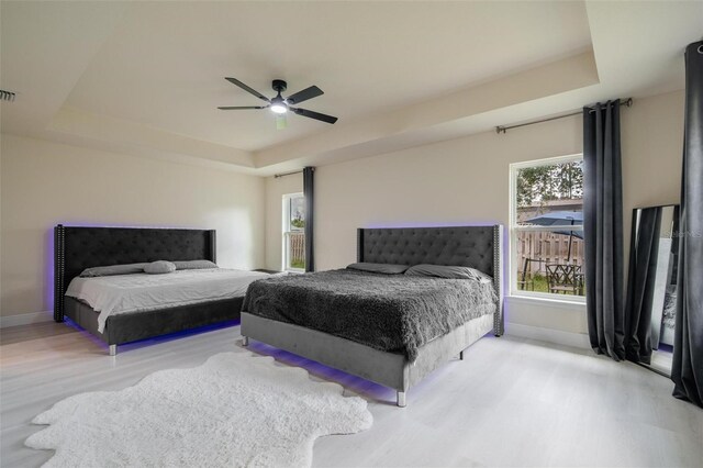 3524 Brownwood Ter, North Port, FL 34286 - bedroom featuring a tray ceiling, wood finished floors, and a ceiling fan