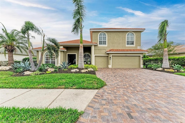 12814 Daisy Pl, Bradenton, FL 34212 - mediterranean / spanish house with stucco siding, a garage, decorative driveway, and a tiled roof
