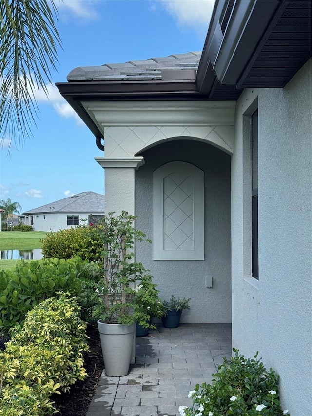 16087 Sunny Day Dr, Bradenton, FL 34211 - view of exterior entry featuring stucco siding and a water view