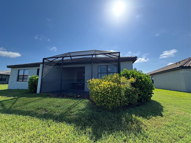 16087 Sunny Day Dr, Bradenton, FL 34211 - rear view of house with a lawn, stucco siding, and a lanai
