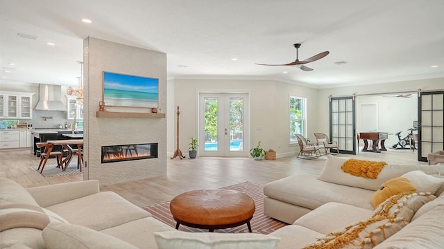 1076 Toc0Baga, Sarasota, FL 34234 - living room with a barn door, recessed lighting, light wood-type flooring, ornamental molding, and ceiling fan