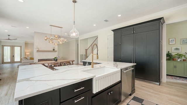 1076 Toc0Baga, Sarasota, FL 34234 - kitchen featuring ornamental molding, stainless steel dishwasher, light wood-style flooring, a center island with sink, and open floor plan