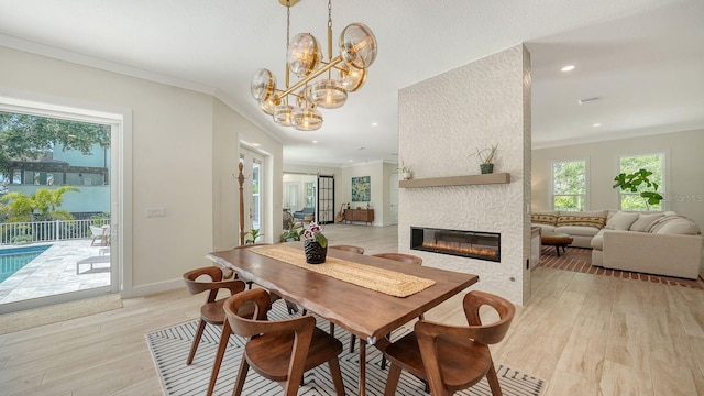 1076 Toc0Baga, Sarasota, FL 34234 - dining area featuring light wood-style floors, ornamental molding, a large fireplace, a chandelier, and recessed lighting