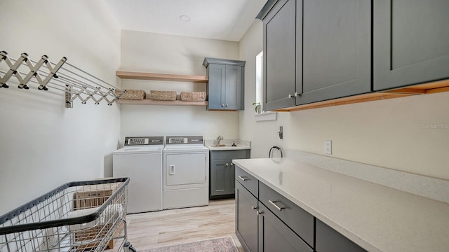 1076 Toc0Baga, Sarasota, FL 34234 - laundry room featuring cabinet space, independent washer and dryer, and light wood-style flooring