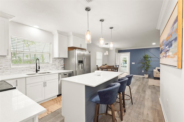 1008 37th St W, Bradenton, FL 34205 - kitchen with stainless steel appliances, backsplash, a kitchen island, light wood finished floors, and recessed lighting