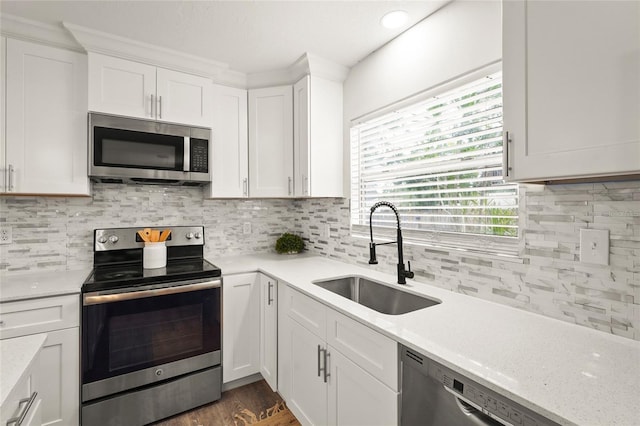 1008 37th St W, Bradenton, FL 34205 - kitchen with appliances with stainless steel finishes, white cabinets, decorative backsplash, and dark wood-style flooring