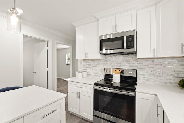 1008 37th St W, Bradenton, FL 34205 - kitchen featuring stainless steel appliances, light countertops, wood finished floors, crown molding, and white cabinetry