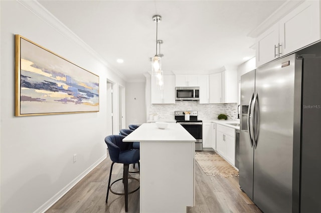 1008 37th St W, Bradenton, FL 34205 - kitchen with appliances with stainless steel finishes, light wood-style flooring, backsplash, crown molding, and a center island
