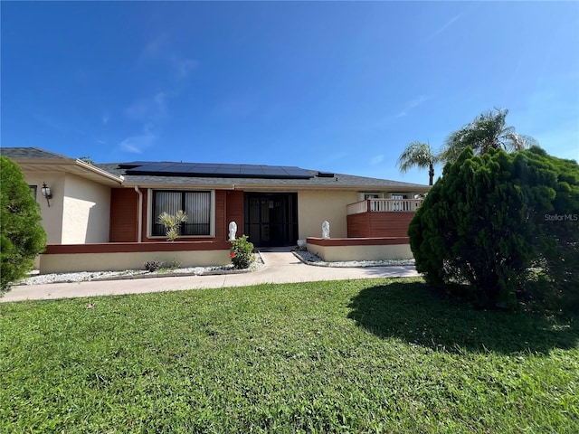 19358 Edgewater Dr, Port Charlotte, FL 33948 - view of front of home featuring solar panels, stucco siding, and a front lawn