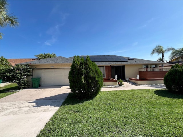 19358 Edgewater Dr, Port Charlotte, FL 33948 - view of front of property with solar panels, an attached garage, stucco siding, a front lawn, and concrete driveway
