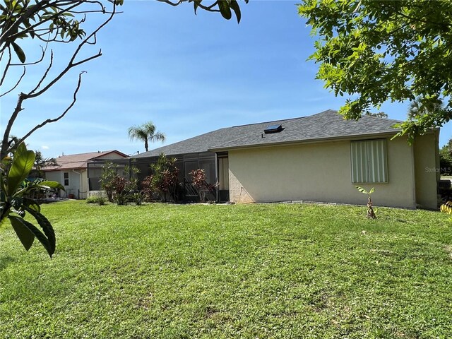 19358 Edgewater Dr, Port Charlotte, FL 33948 - view of side of property with stucco siding and a lawn