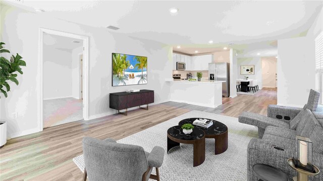 12039 Lansing Gln, Parrish, FL 34219 - living room featuring light wood finished floors and recessed lighting