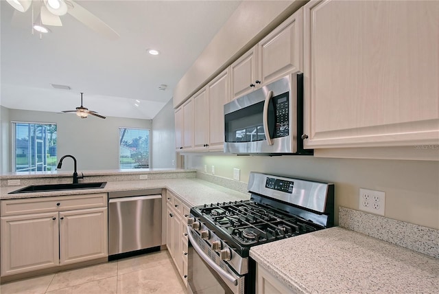 5080 Timber Chase Way, Sarasota, FL 34238 - kitchen featuring appliances with stainless steel finishes, ceiling fan, lofted ceiling, light tile patterned floors, and light stone counters