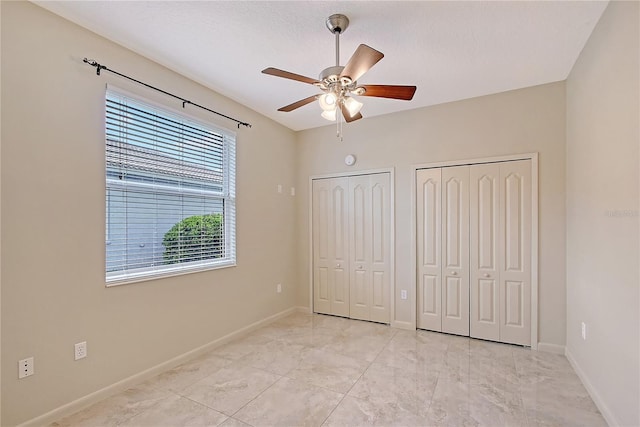 5080 Timber Chase Way, Sarasota, FL 34238 - unfurnished bedroom featuring two closets, light marble finish flooring, and ceiling fan